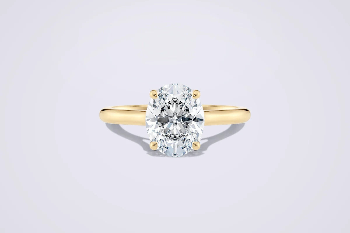 Oval diamant i klassisk enstensinnfatning av gult gull. Illustrerer hvordan ovale diamanter gir størrelsesillusjon og elegant form