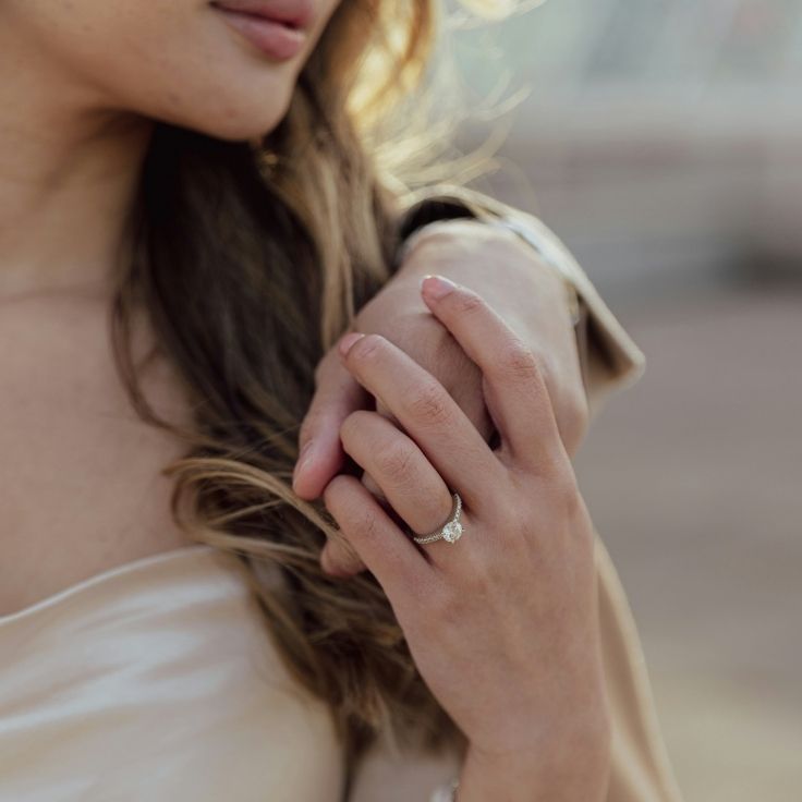 Forlovelsesring i hvitt gull med sidediamanter på hånden til modell