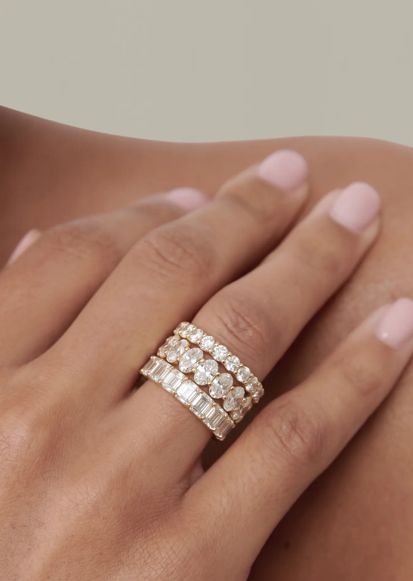 Hånd med tre evighetsringer i gult gull med rader av diamanter