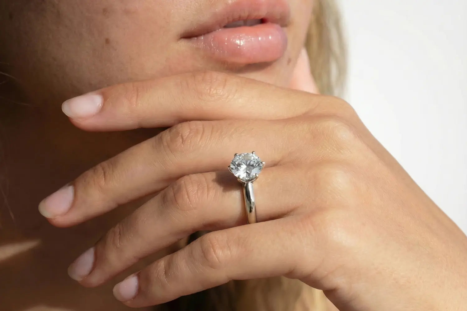Forlovelsesring dame i hvitt gull med rund lab diamant vist på hånd
