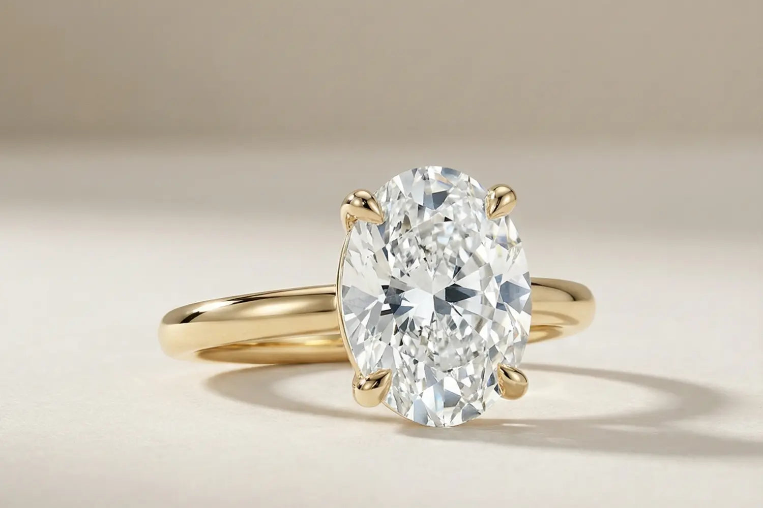 Oval diamant forlovelsesring i gult gull med lab diamant og fire klør – nærbilde på ring