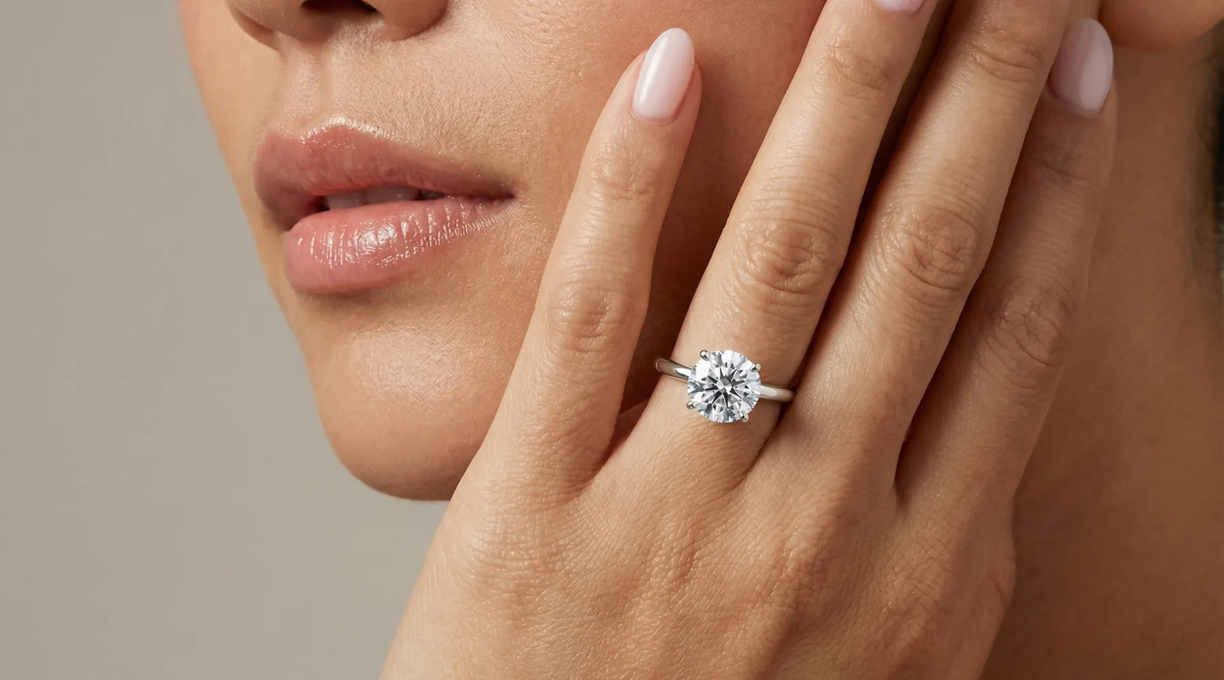 Nærbilde av en forlovelsesring i hvitt gull med 2,00 ct lab-diamant på en finger  til modell – klassisk Hartwell-design 