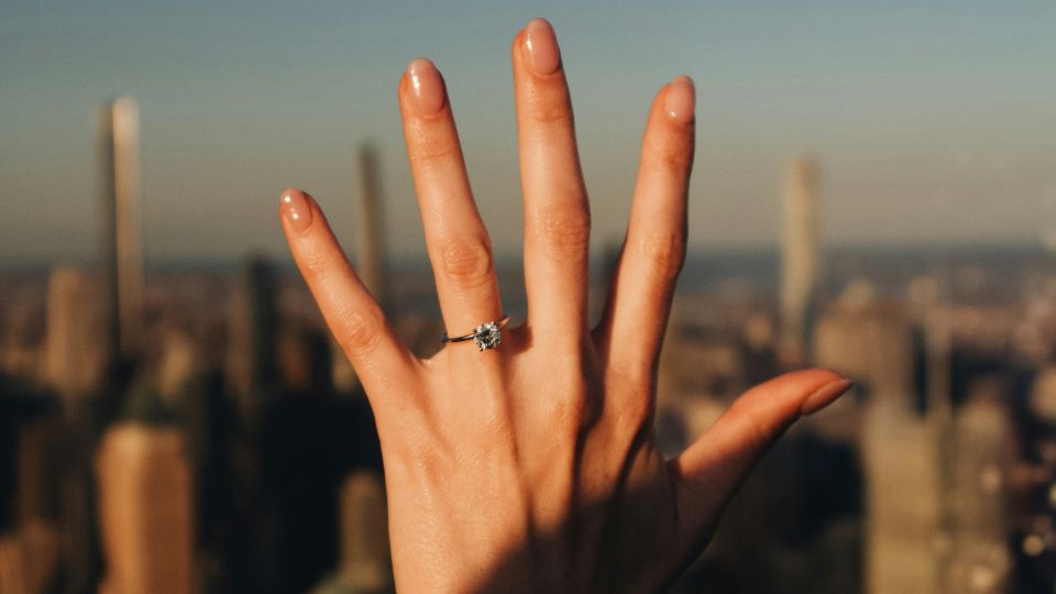 Hva burde en forlovelsesring koste - hånd med diamantring som viser forlovelsesring budsjett