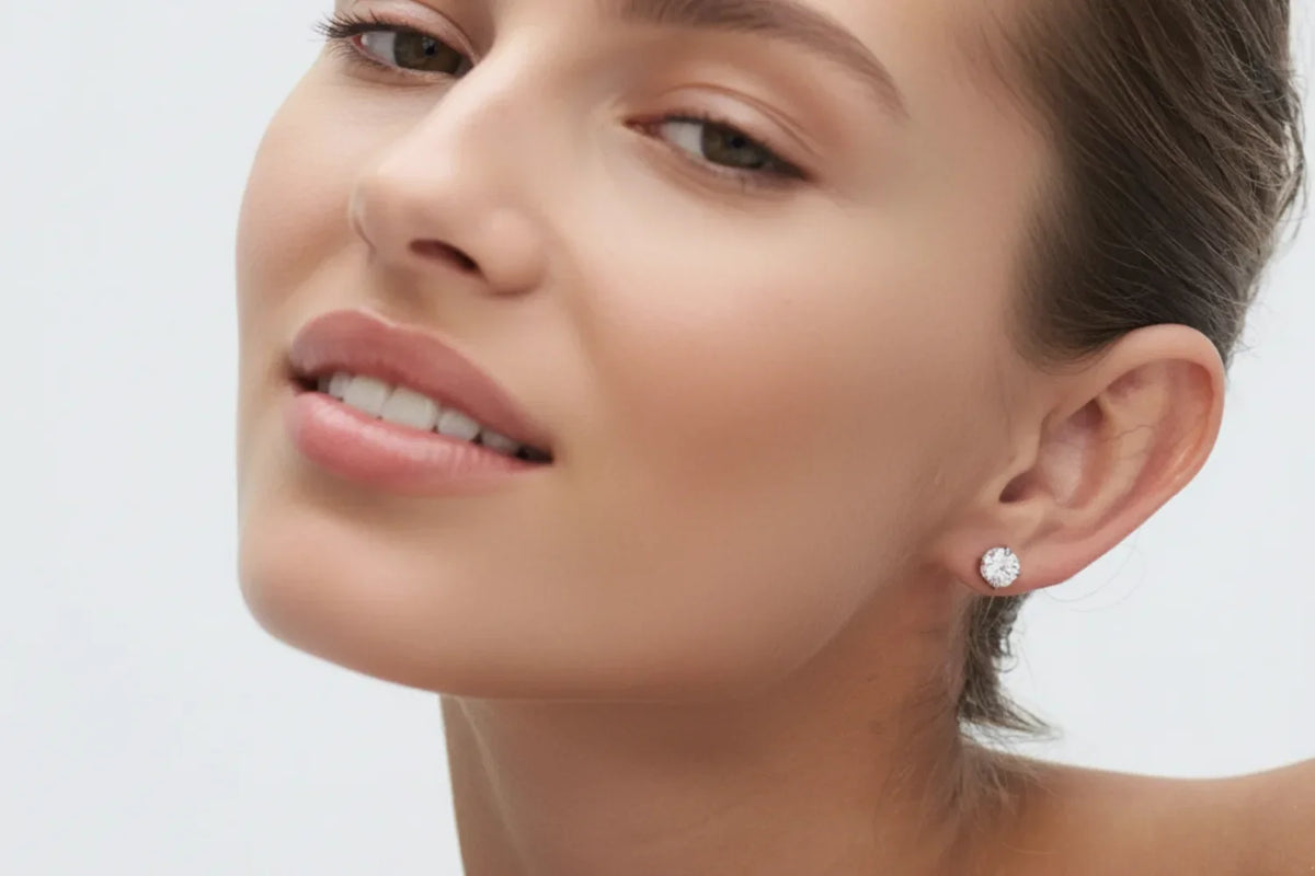 Smilende modell med 1 carat lab diamantøredobb i hvitt gull