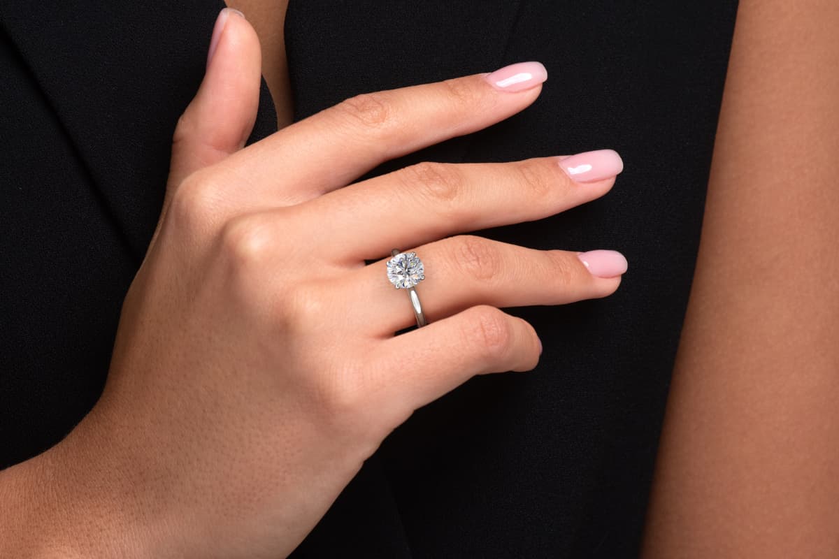 Hånd med forlovelsesring i resirkulert hvitt gull med 2 carat lab-diamant – Hartwell