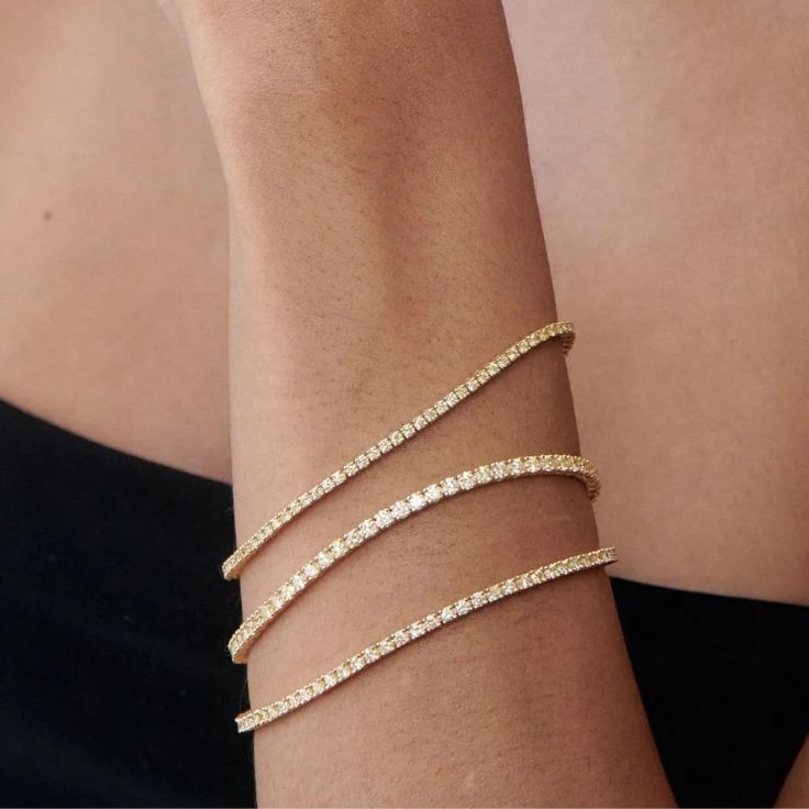 diamantarmbånd og tennisarmbånd i gult gull på armen til modell