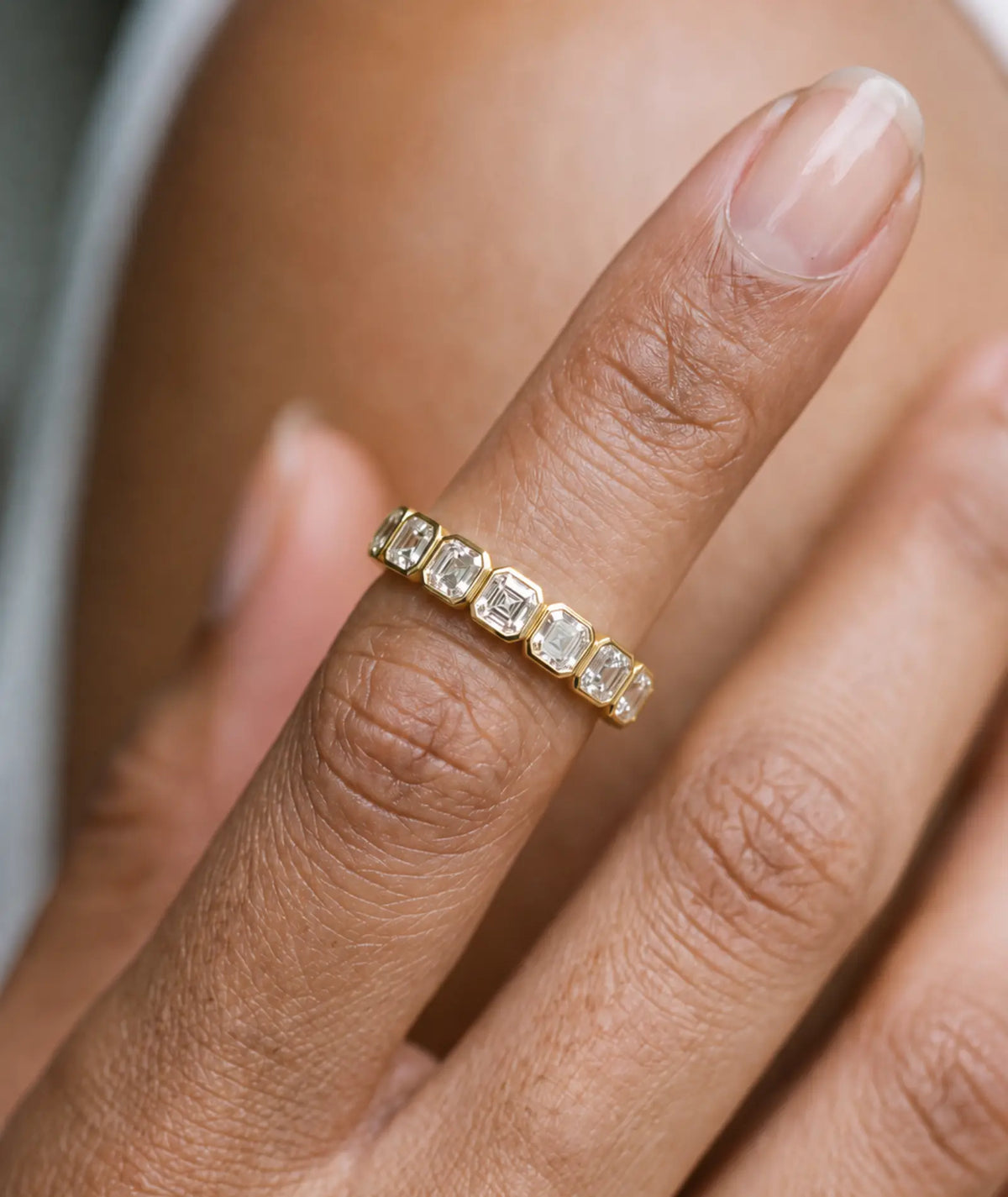 Asscher Cut Bezel Eternity Ring i 14K gult gull med 1,90 ct laboratoriedyrkede diamanter, båret på finger, bezelinnfatning.