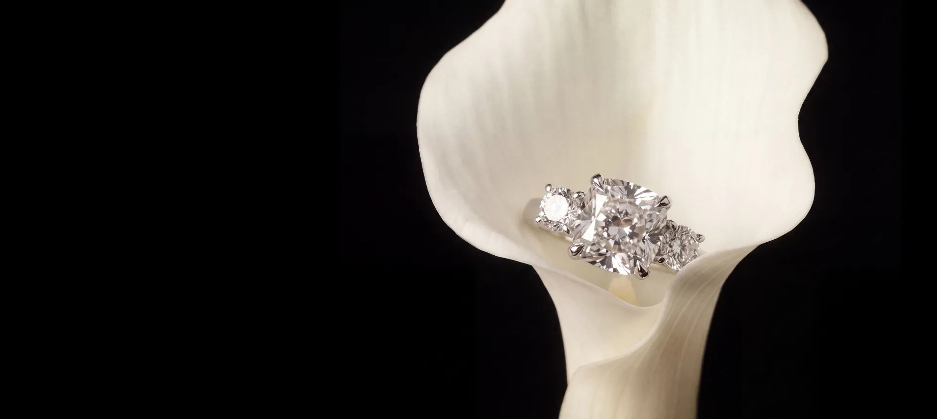 En custom diamantring laget av Hartwell. hviler i en blomst