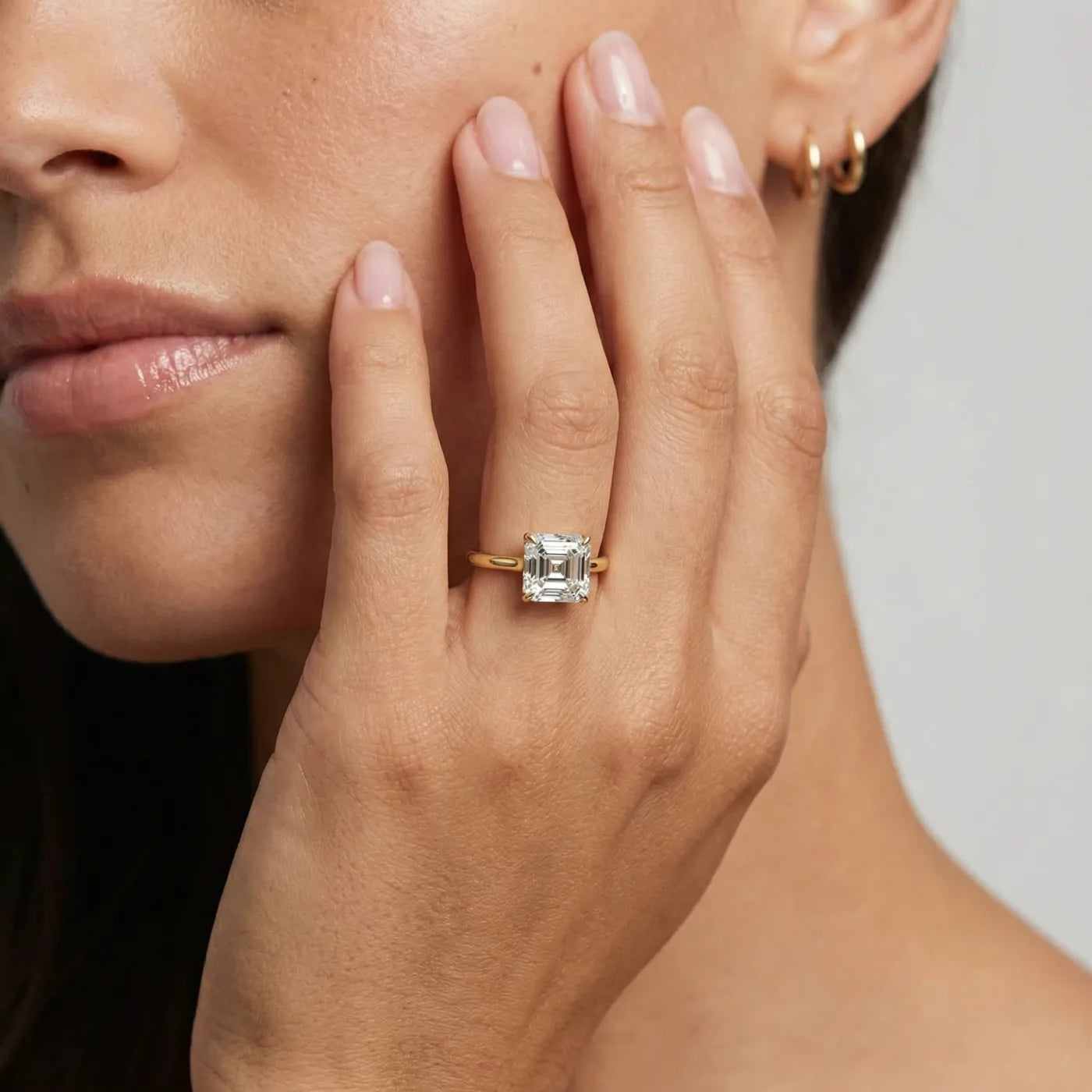 1 carat Asscher cut diamantring i gult gull med lab diamant vist på modell i naturlig lys