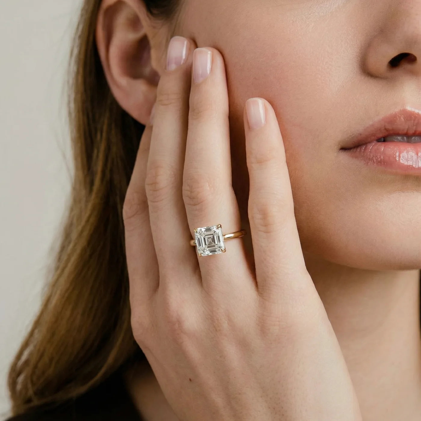 2 carat Asscher cut diamantring i gult gull med lab diamant vist på modell i naturlig lys