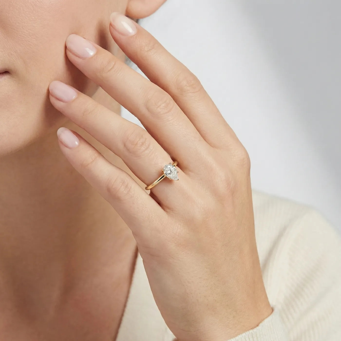 Diamantring i gult gull med 0,50 carat dråpe-formet lab diamant vist på modell i naturlig lys