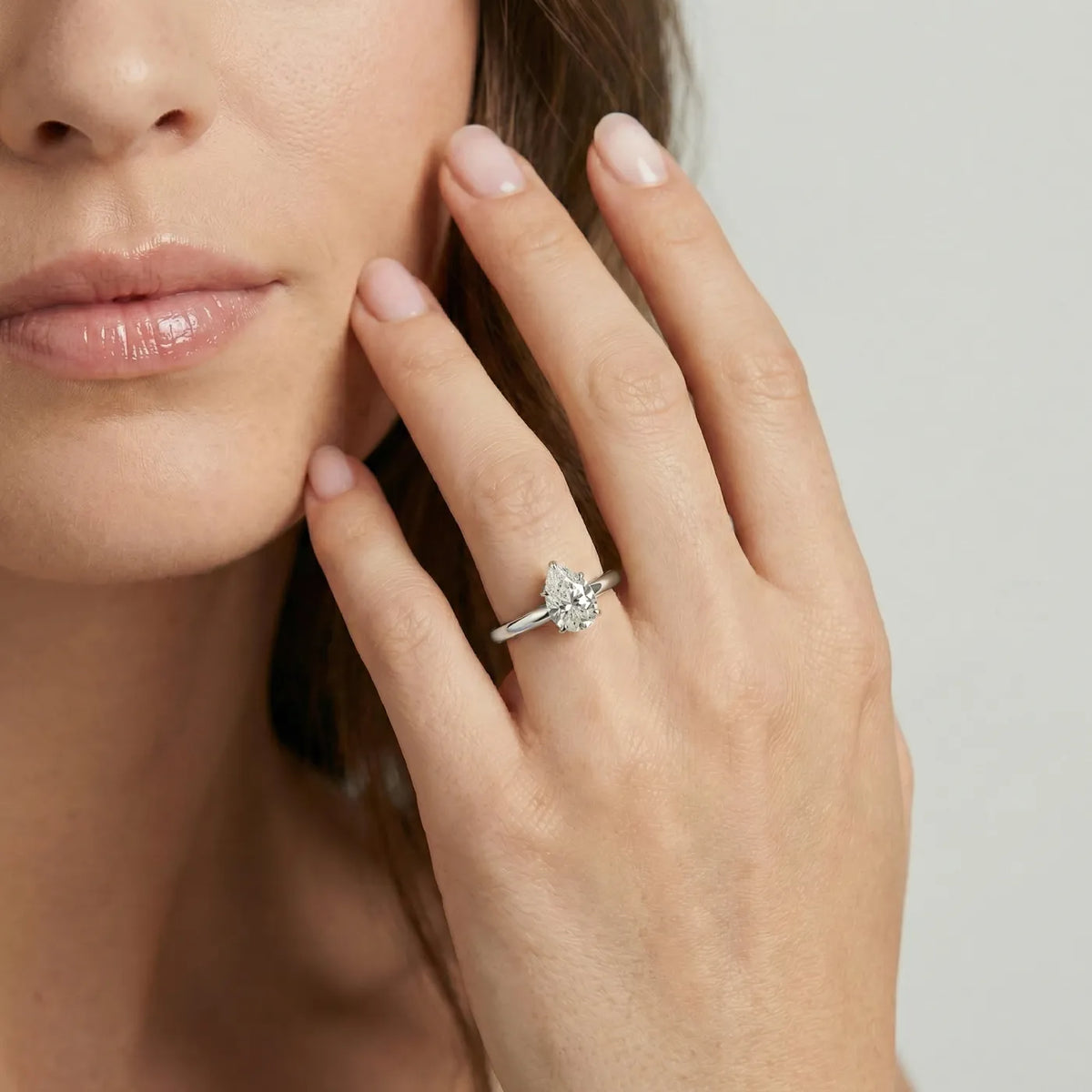 Diamantring i hvitt gull med 1 carat dråpe-formet lab diamant vist på modell i naturlig lys