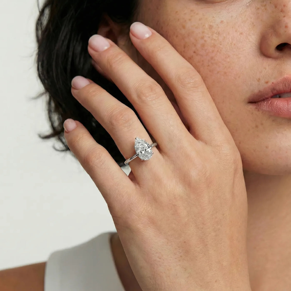 Diamantring i hvitt gull med 2 carat dråpe-formet lab diamant vist på modell i naturlig lys