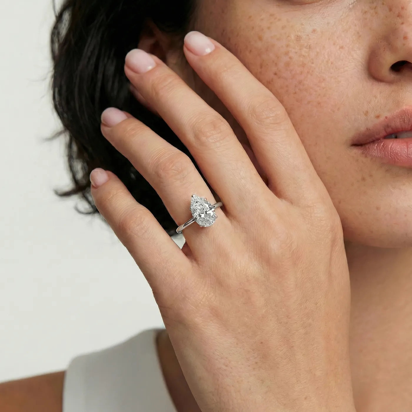 Diamantring i hvitt gull med 2 carat dråpe-formet lab diamant vist på modell i naturlig lys