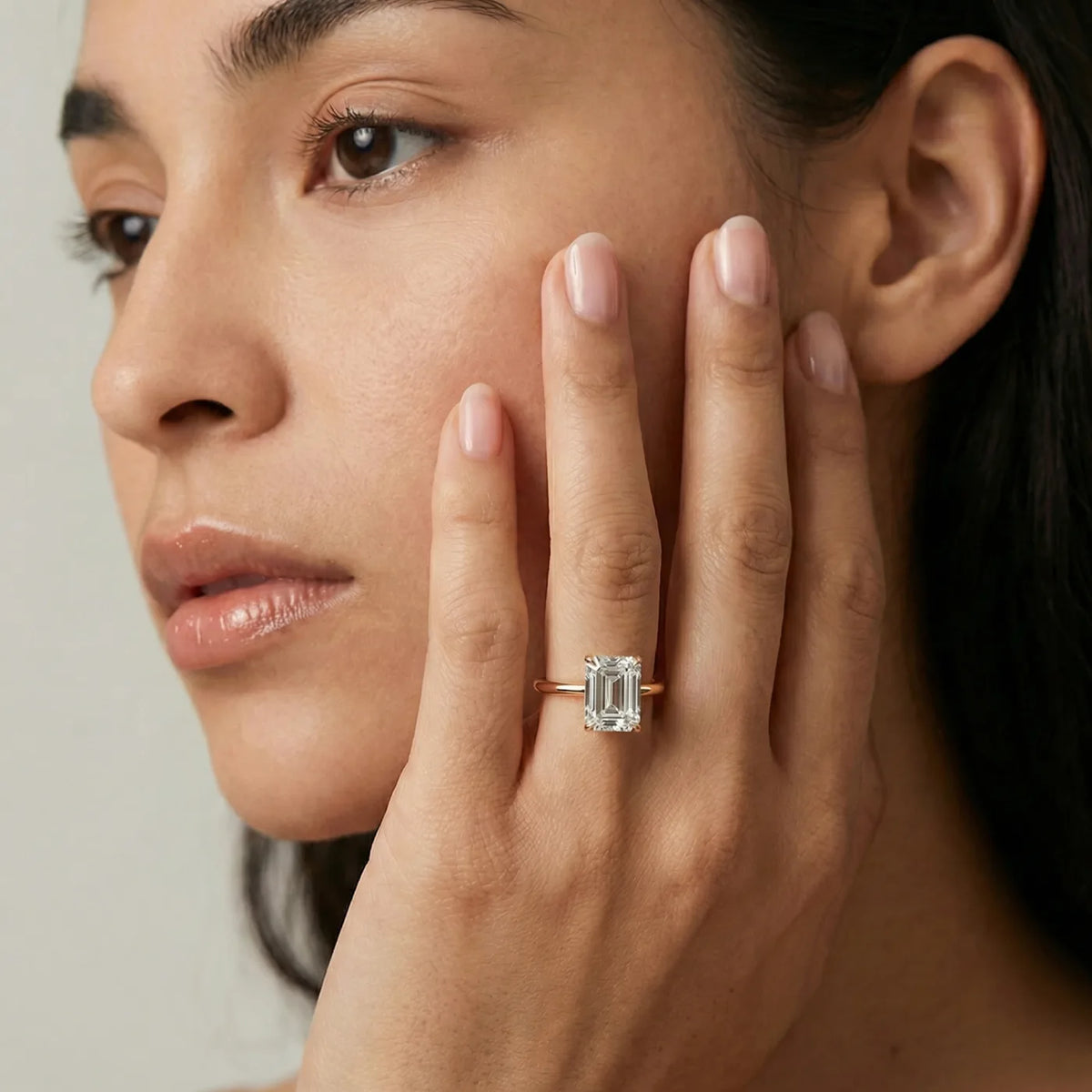 2 carat emerald cut diamantring i rosegull med lab diamant vist på modell i naturlig lys