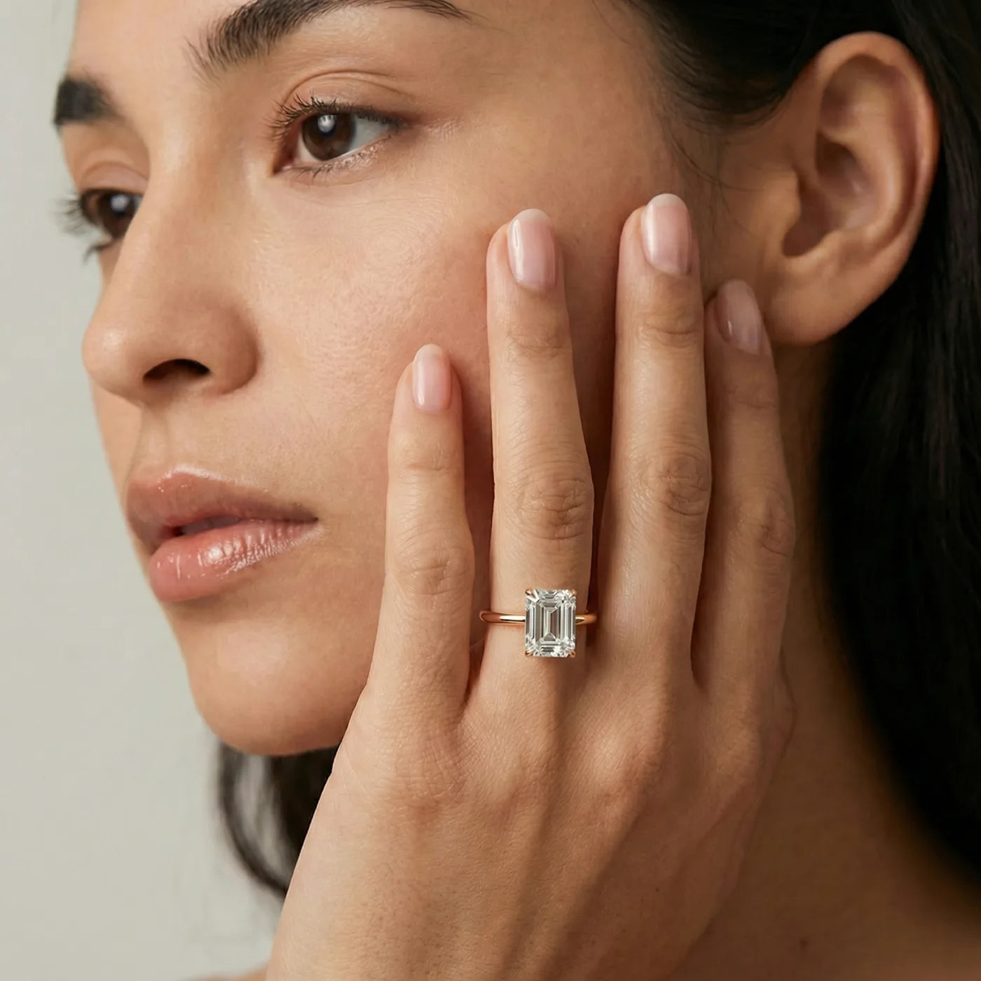 2 carat emerald cut diamantring i rosegull med lab diamant vist på modell i naturlig lys