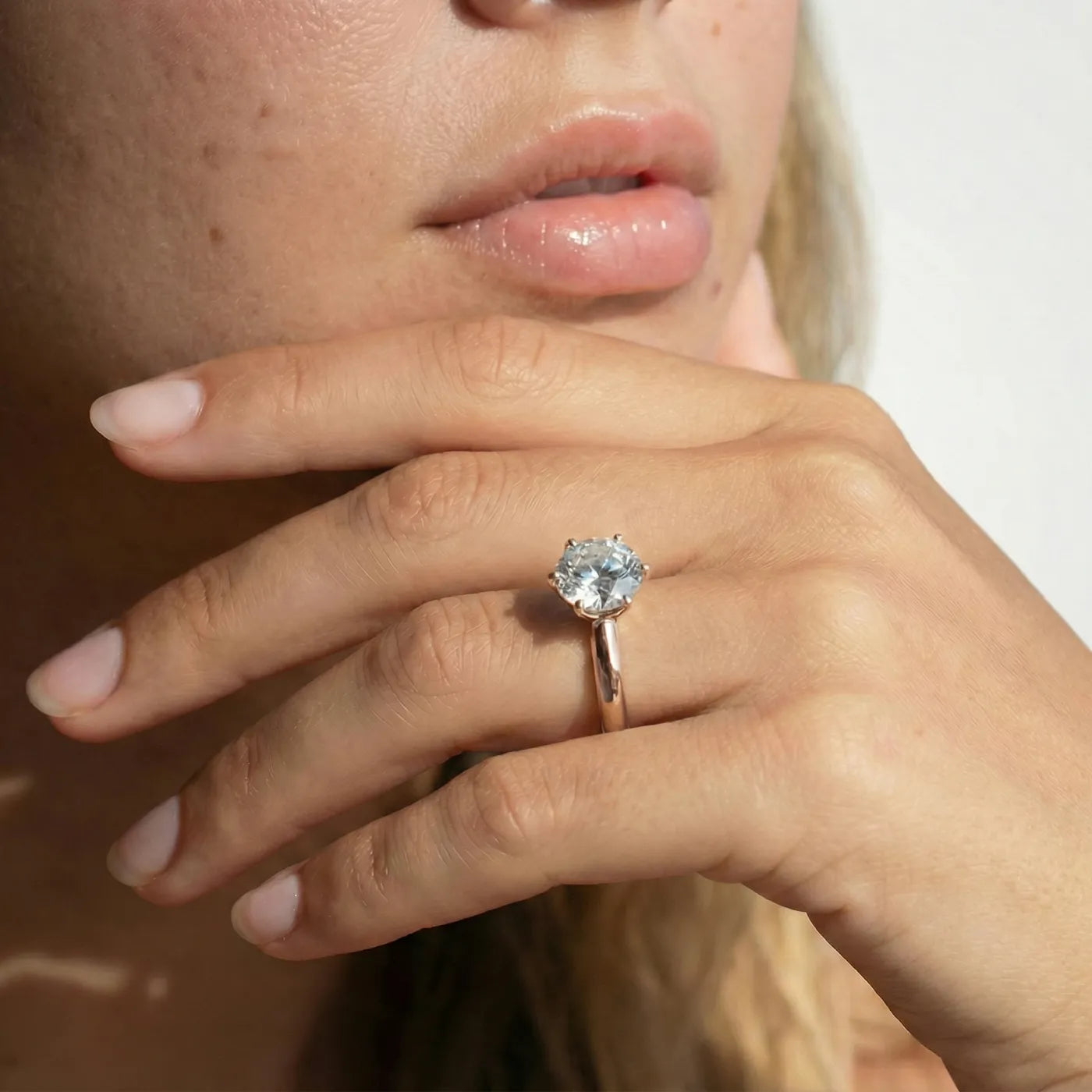 2 carat knife edge diamantring i rosegull med lab diamant vist på modell i naturlig lys.