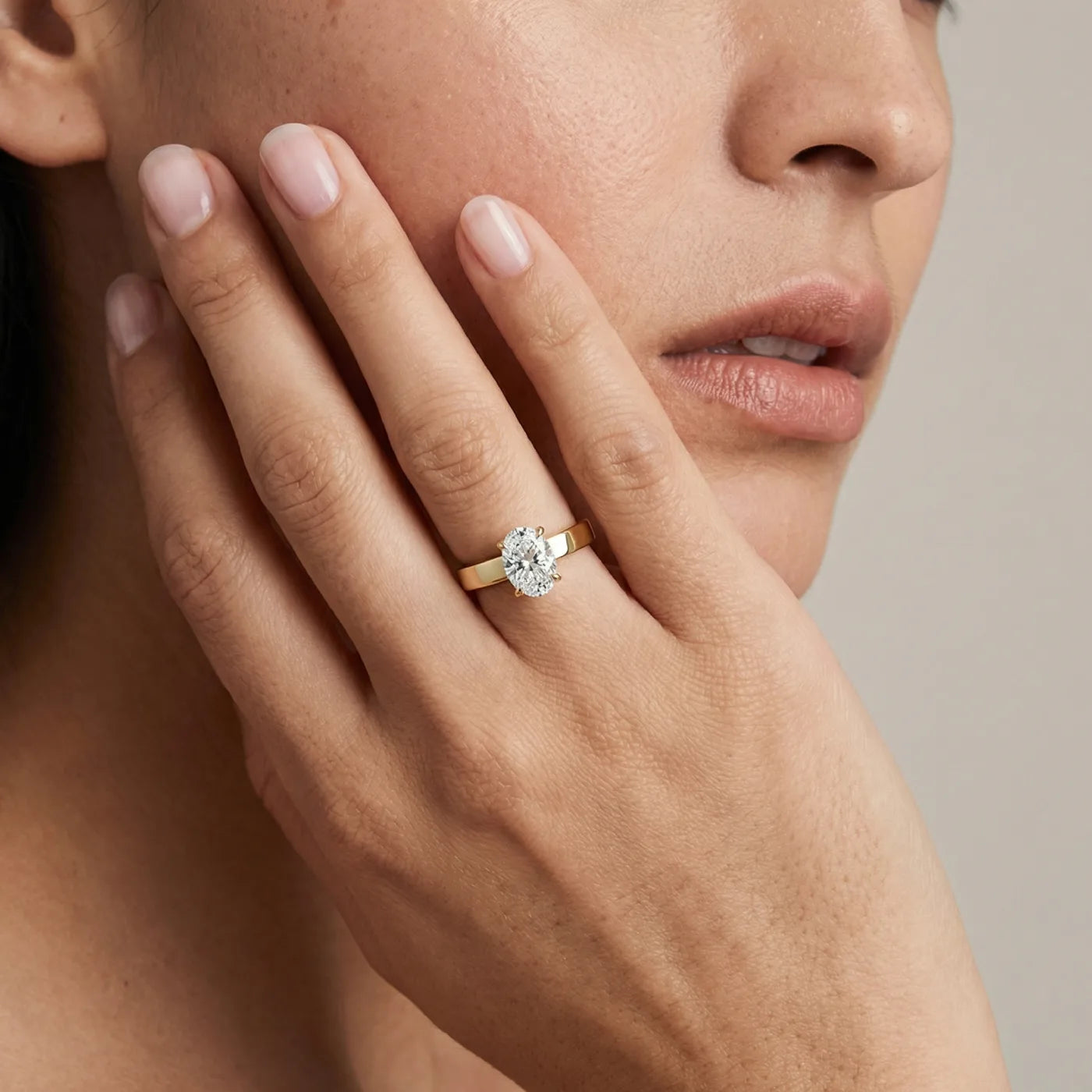 Diamantring med 1 carat oval diamant med cigar bånd 3 mm i gult gull vist på modell.