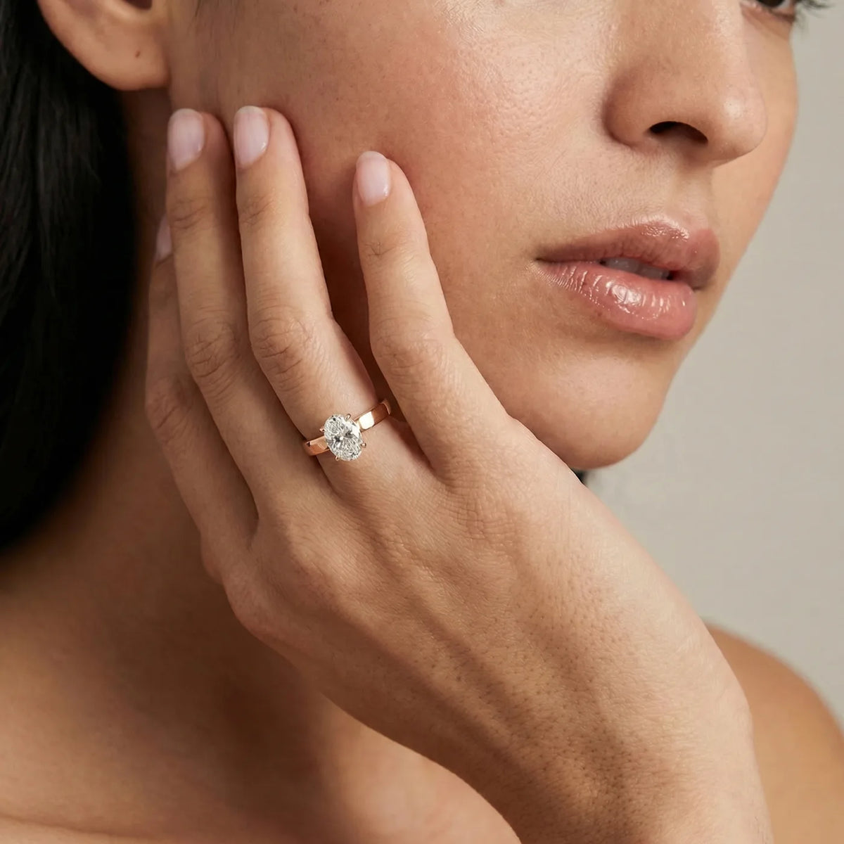 Diamantring med 1 carat oval diamant med cigar bånd 3 mm i rosegull vist på modell.