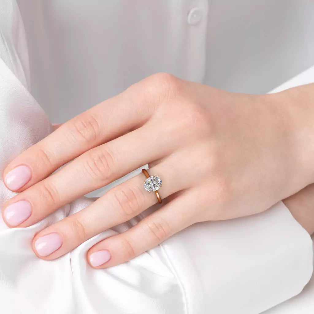 Diamantring oval roségull 2 ct lab diamant, vist på fingeren til en modell, designet av Hartwell.
