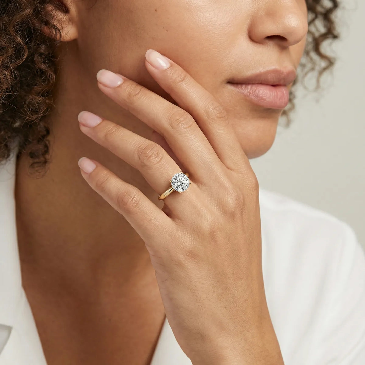 2 ct tapered diamantring i gult gull med lab diamant vist på modell i naturlig lys