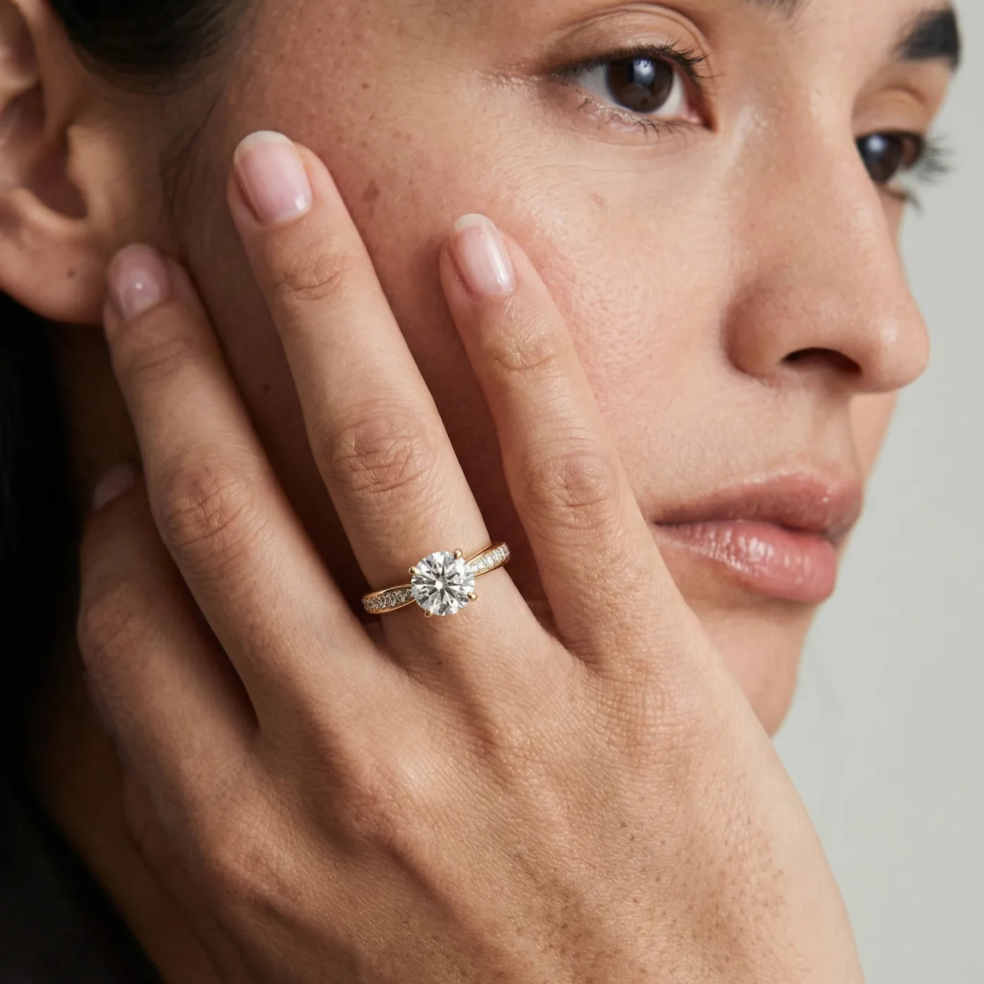Tapered diamantring i gult gull med pave diamanter 1,27 carat på modell i naturlig lys.