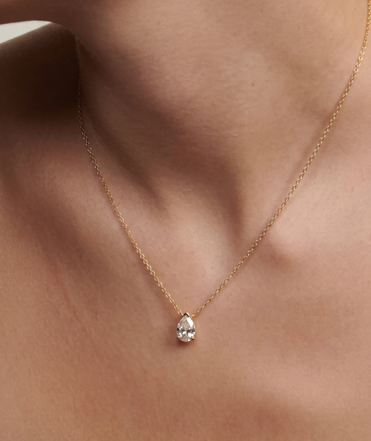 Dråpeformet diamanthalskjede i kloinnfatning, 14K gult gull på modell.