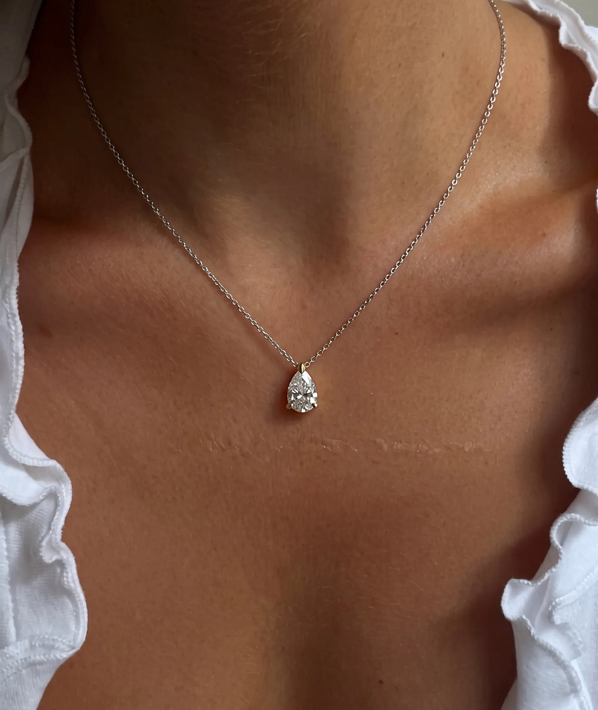 Dråpeformet diamanthalskjede i kloinnfatning, 14K hvitt gull på modell.