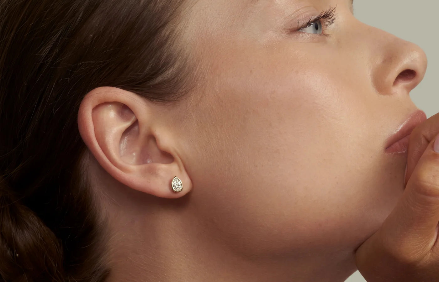 Enstens diamantøredobb, dråpeformet diamant med bezel innfattning i øret på modell. 