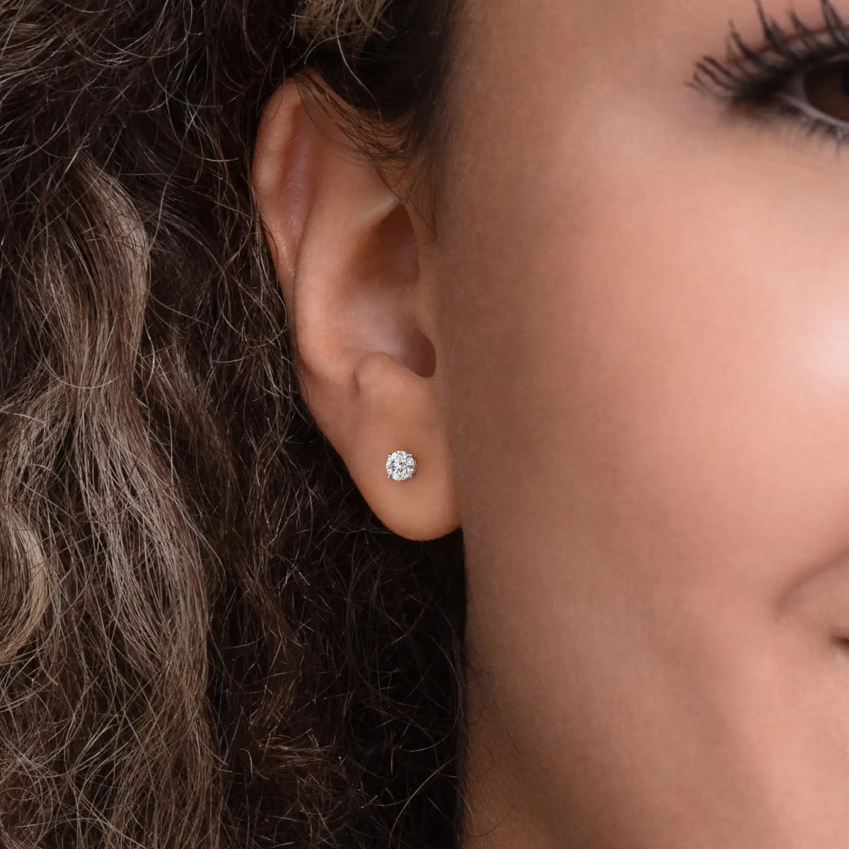 Enstens diamantøredobb i hvitt gull 0,60 ct med fire klør – vist i øret på modell.