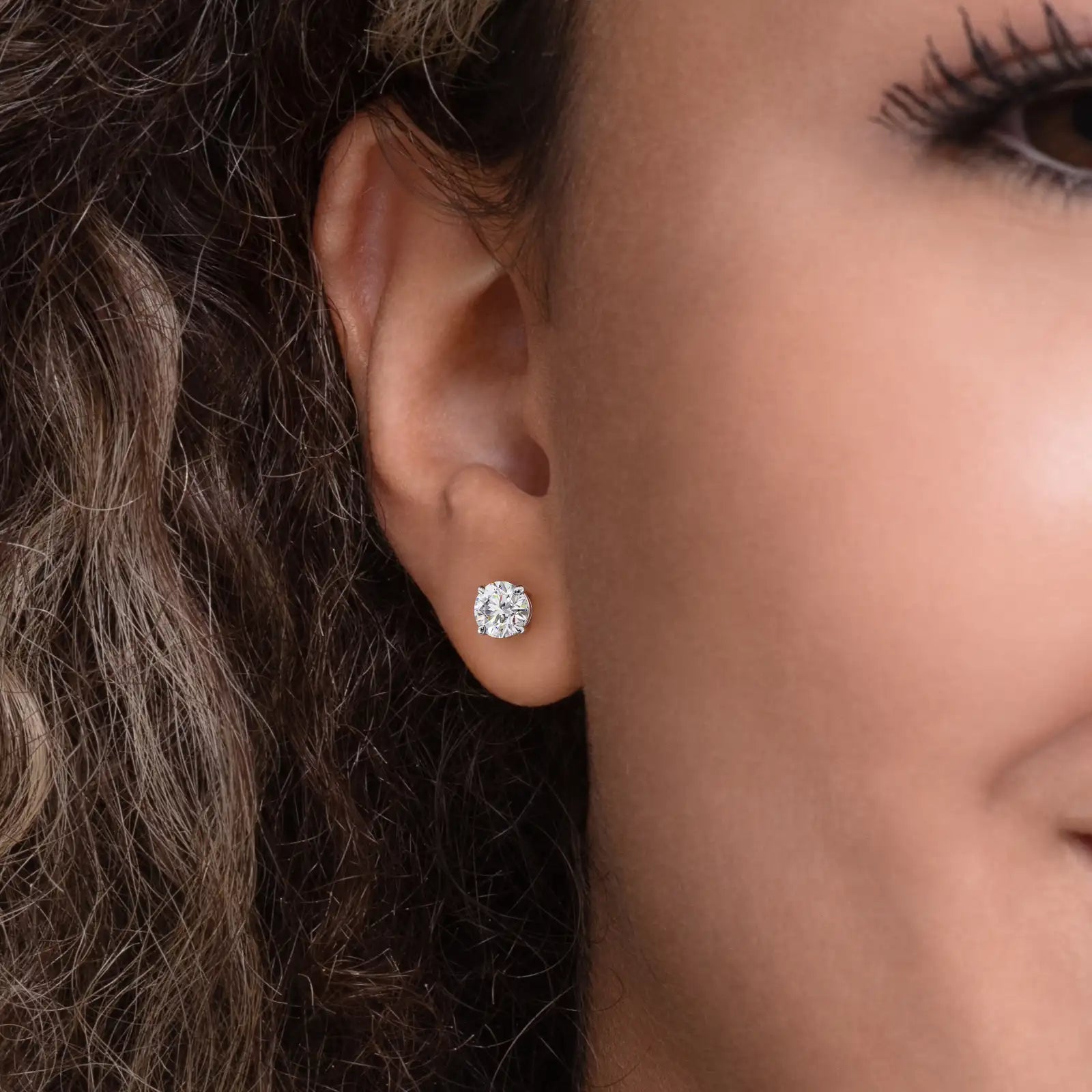 Enstens diamantøredobb i hvitt gull 2,00 ct med fire klør – vist i øret på modell.