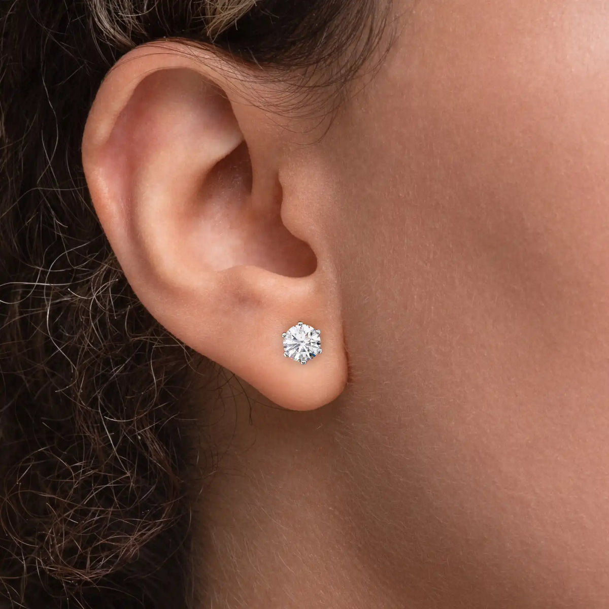 Enstens diamantøredobb i hvitt gull 2,00 ct med seks klør – vist i øret på modell