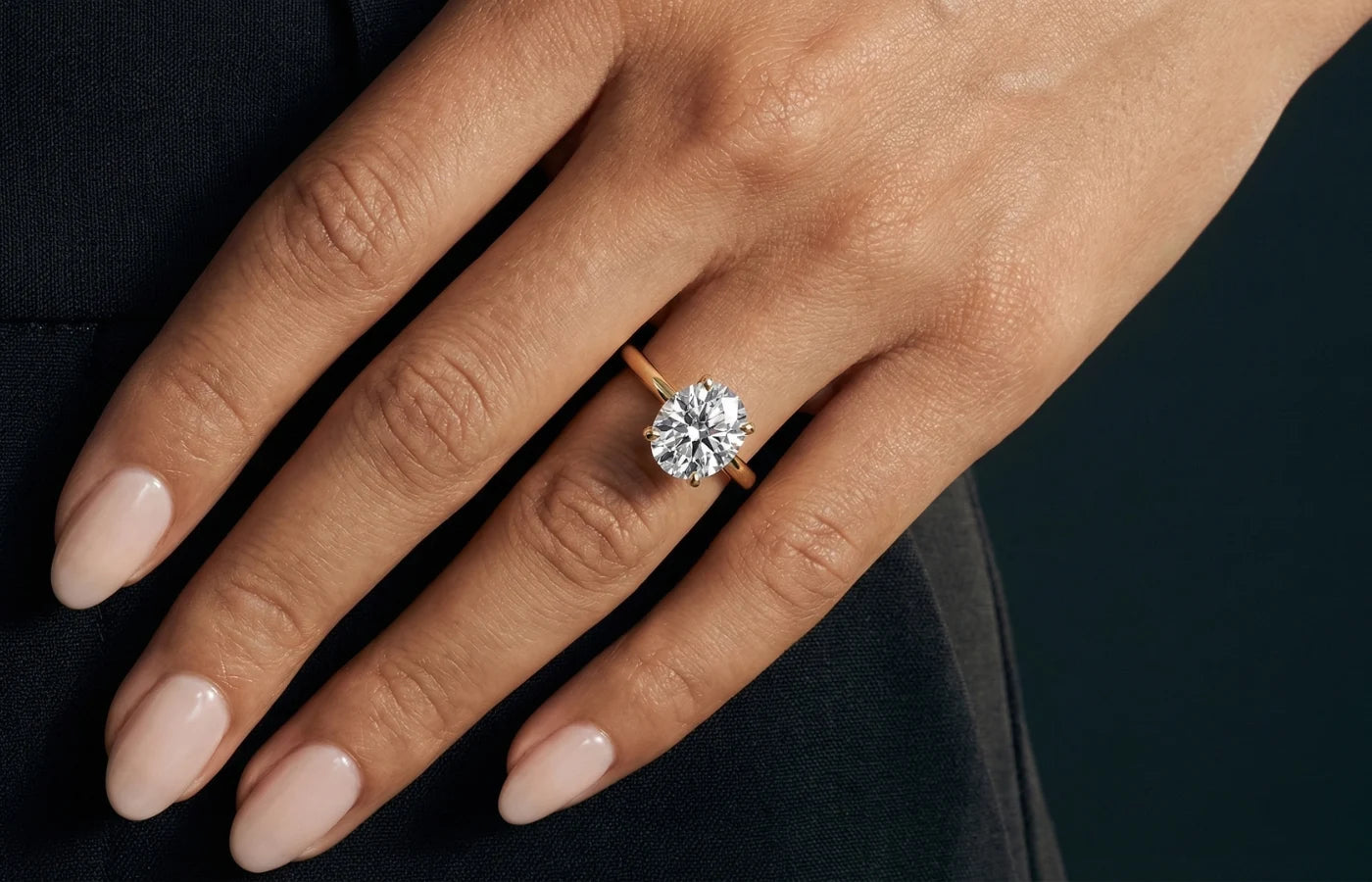 Forlovelsesring til dame i gull og diamant på fingeren til modell. 
