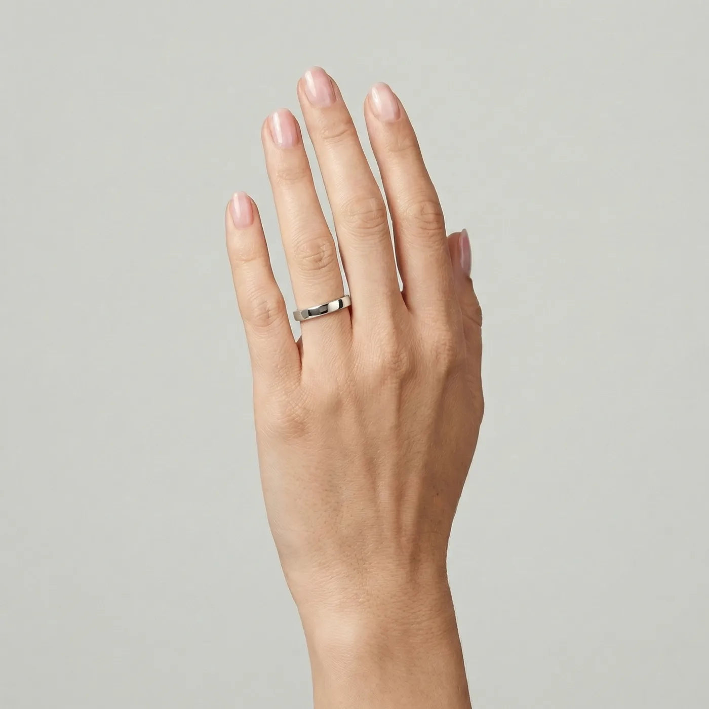 Giftering i flat form 3 mm bred i hvitt gull, vist på hånd. 