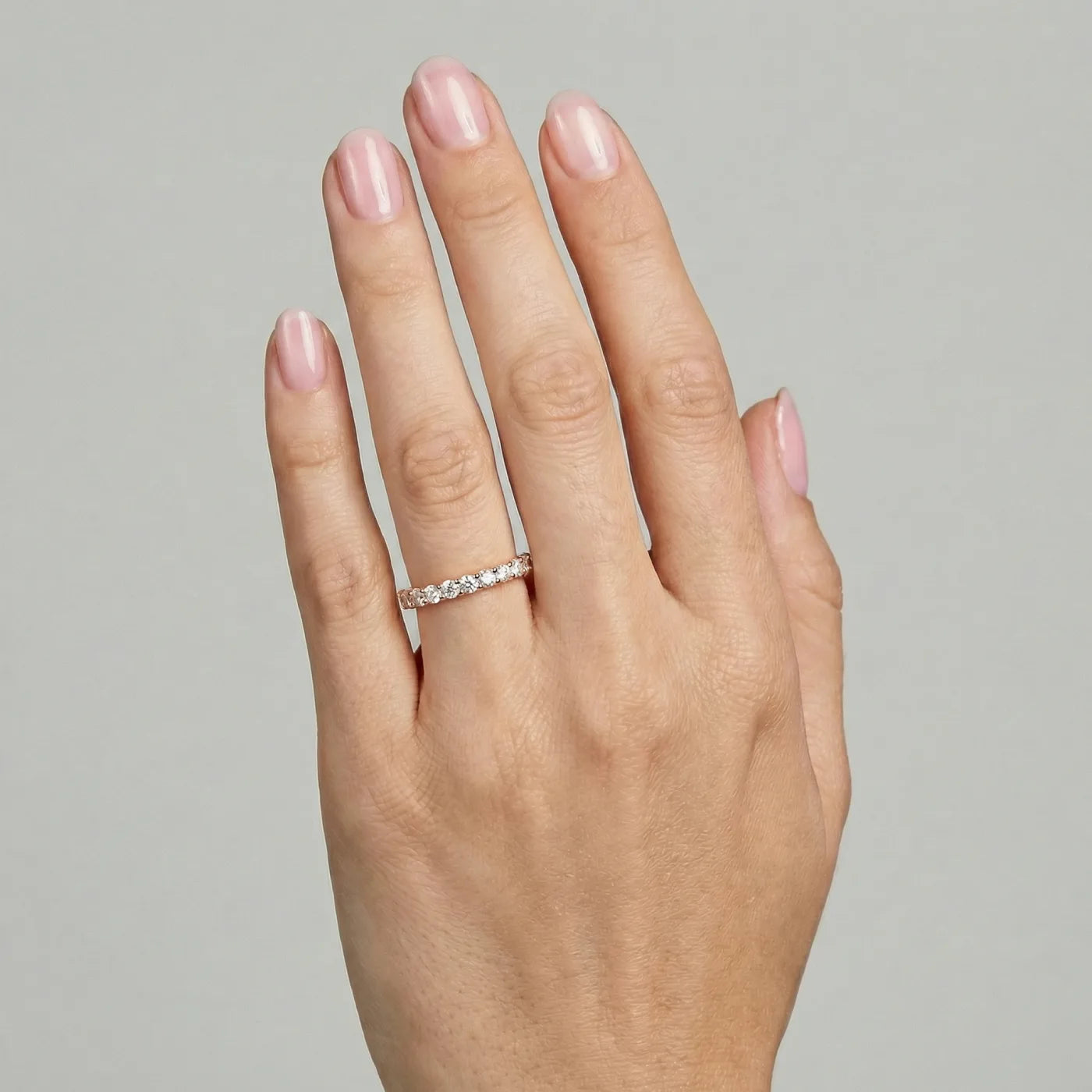Halv alliansering i rosegull med 0,60 carat diamanter vist på hånden til modell