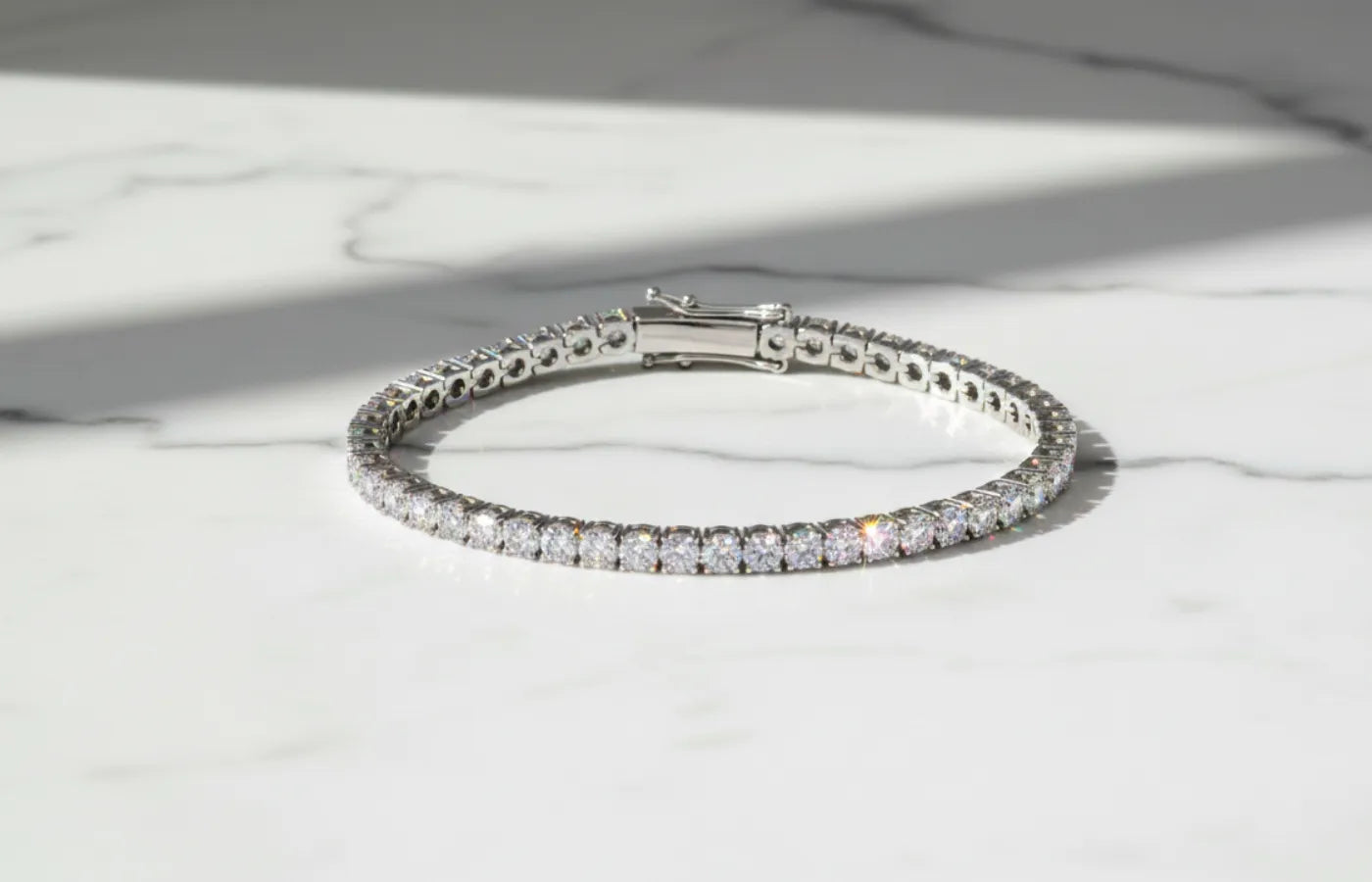 Tennisarmbånd med lab diamanter i hvitt gull på marmorplate.