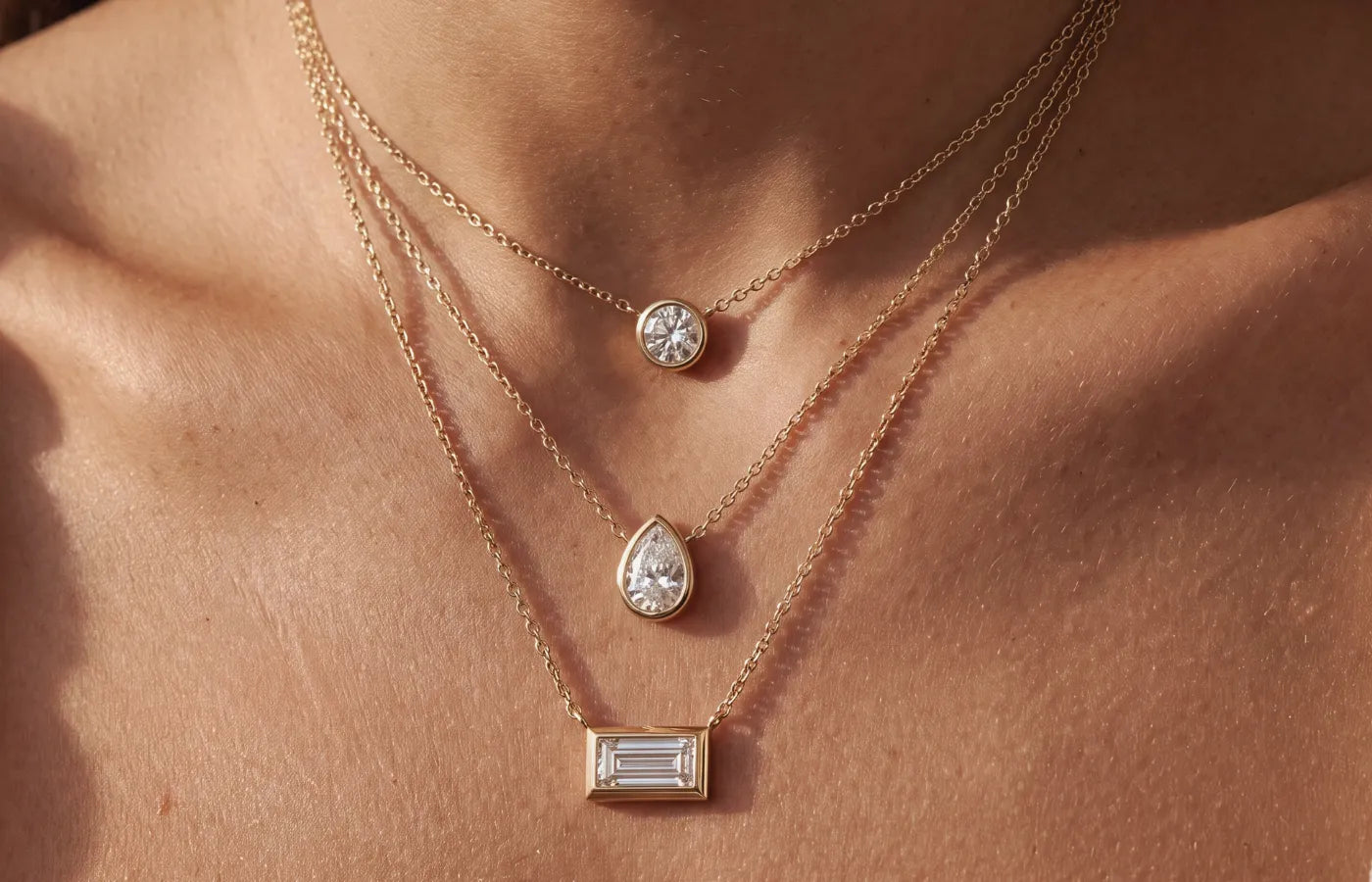 Halskjeder i gult gull med dråpeformet, rund og baguett slipt diamant i bezel innfattning fra Hartwell