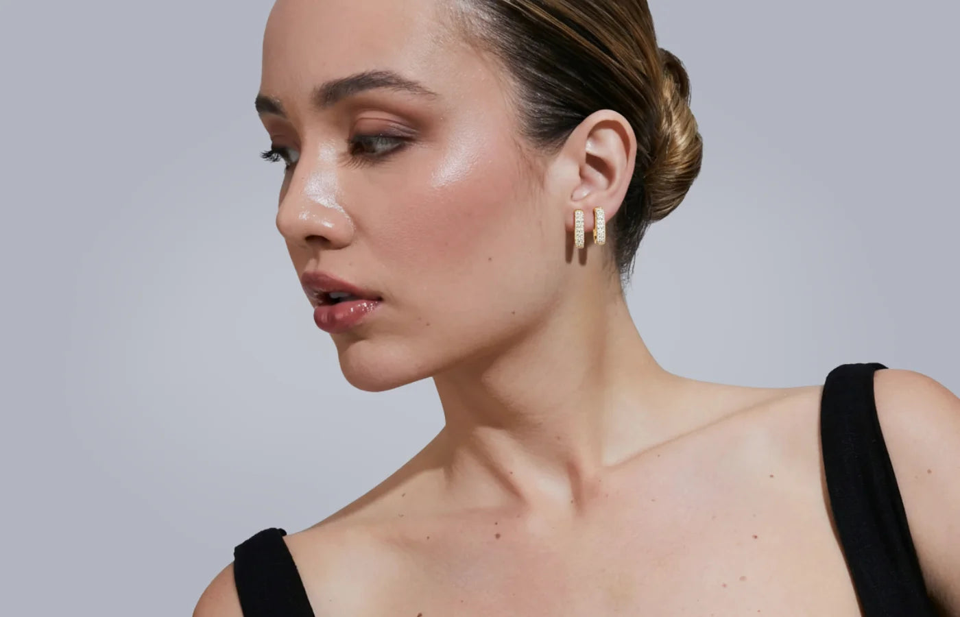 Øreringer i gult gull med lab diamanter fra Hartwell, i øret til modell. 