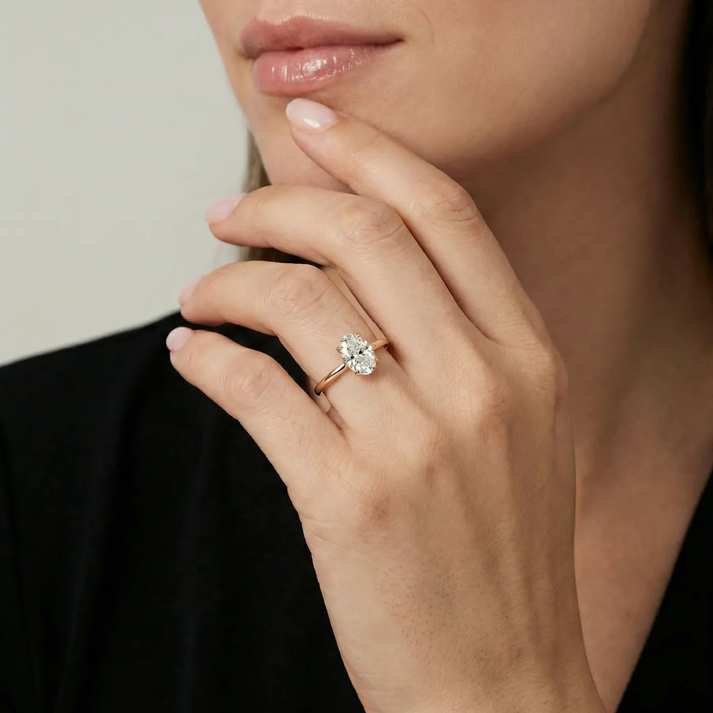oval forlovelsesring i rosegull med 0,50 carat lab diamant vist på modell i naturlig lys