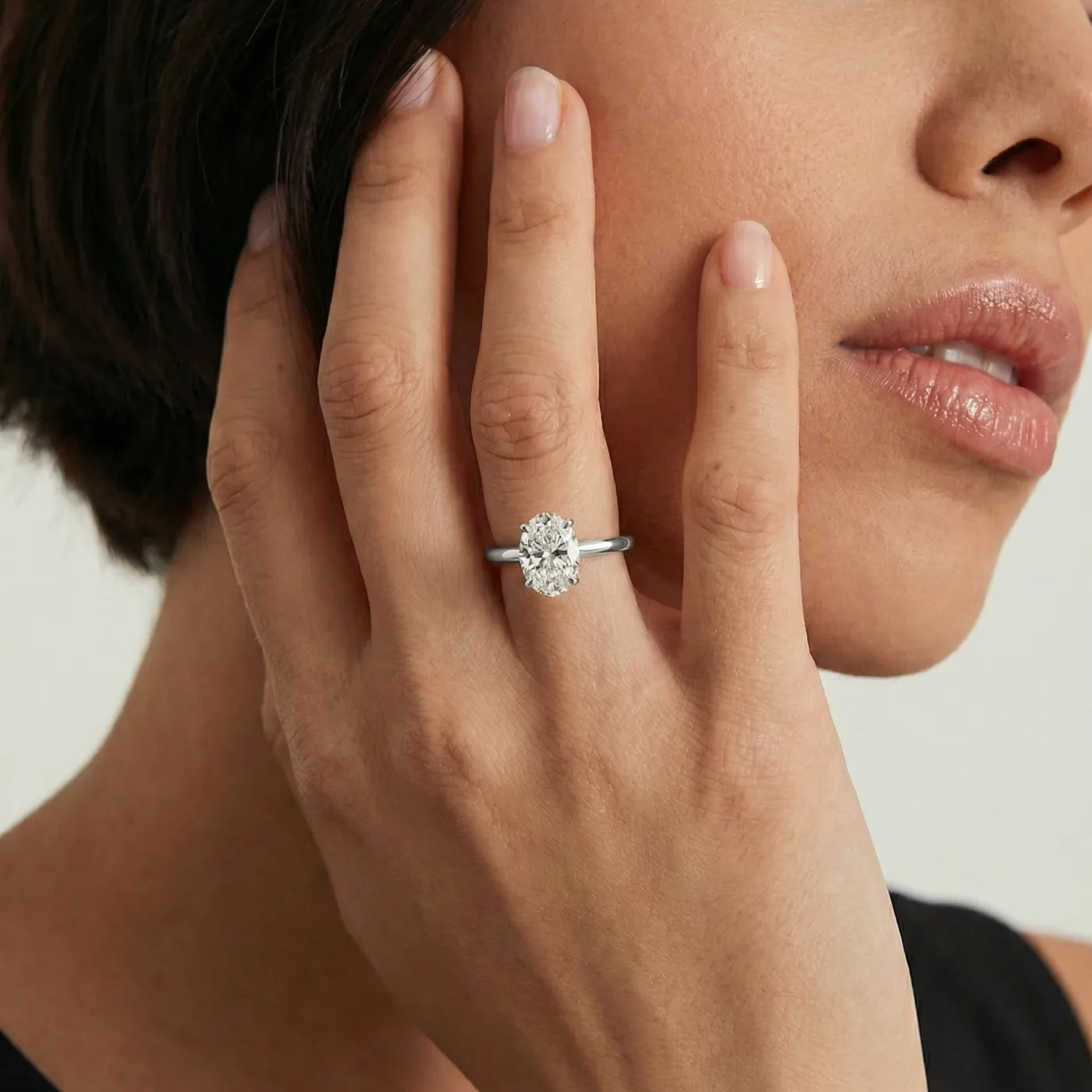 Oval forlovelsesring i hvitt gull med 1 carat lab diamant vist på modell i naturlig lys