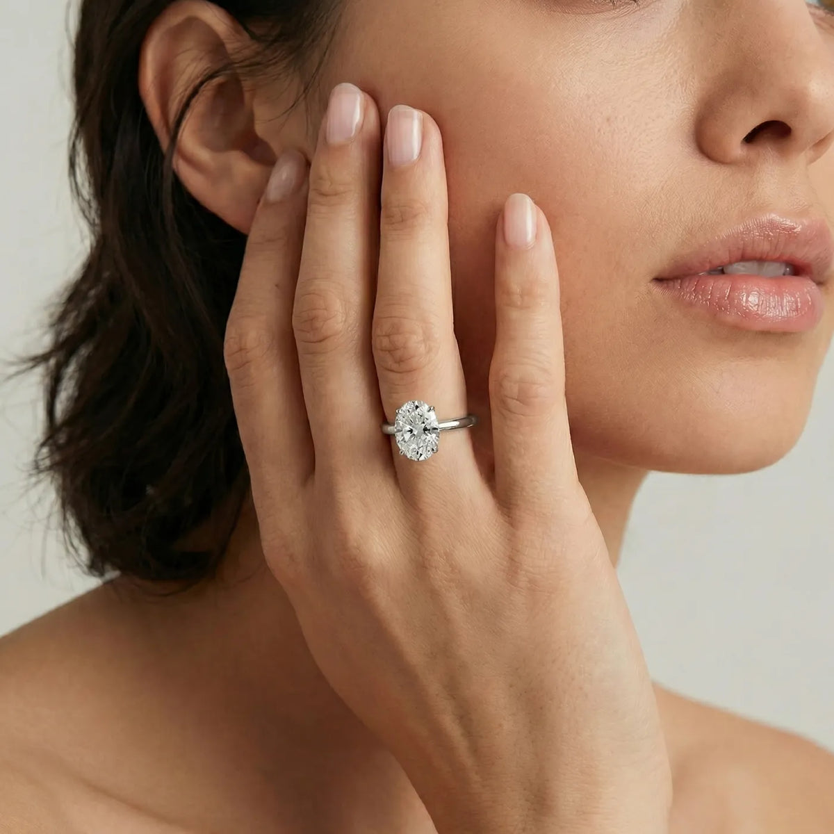 Oval forlovelsesring i hvitt gull med 2 carat lab diamant vist på modell i naturlig lys