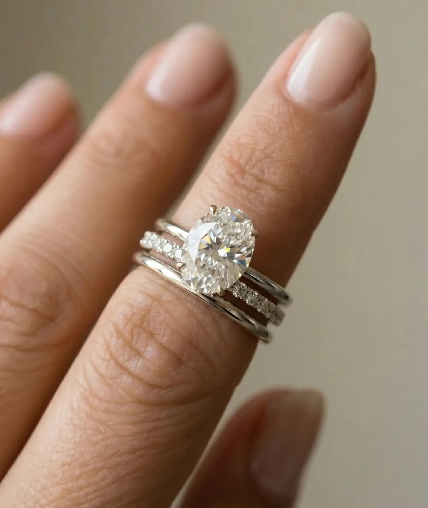 Oval forlovelsesring i hvitt gull 2 carat lab diamantpå hånden til modell i naturlig lys.