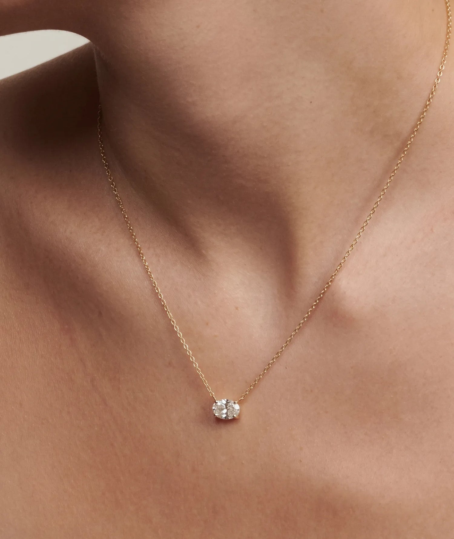 Ovalt diamanthalskjede i kloinnfatning, 14K gult gull på modell.