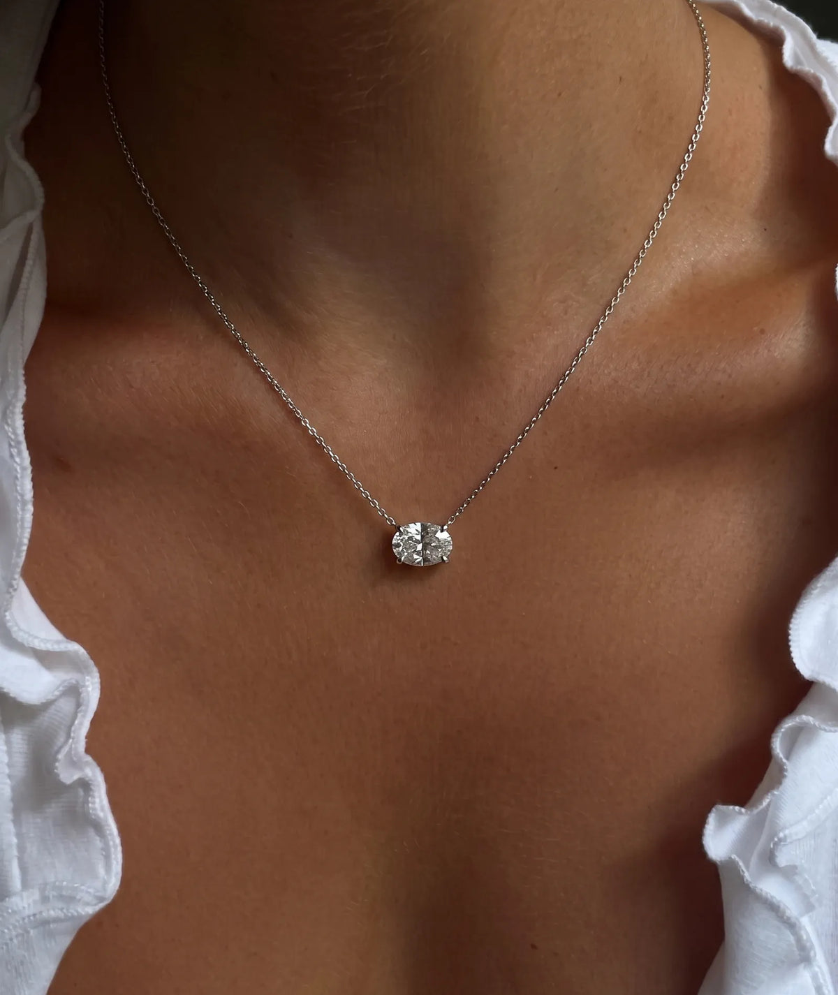 Ovalt diamanthalskjede i kloinnfatning, 14K hvitt gull på modell.