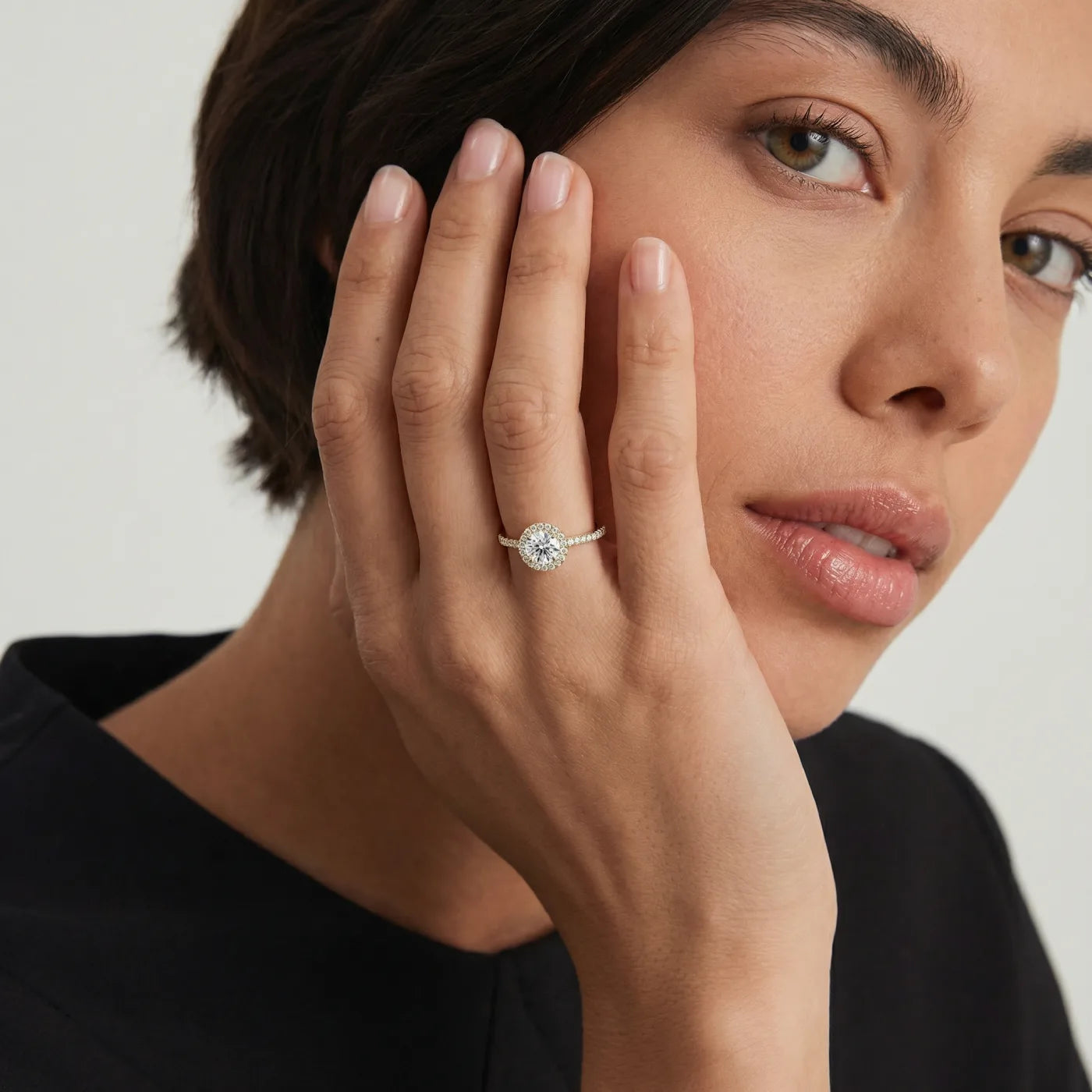 Rosettring i gult gull med 0.82 carat diamanter på modell i naturlig lys.