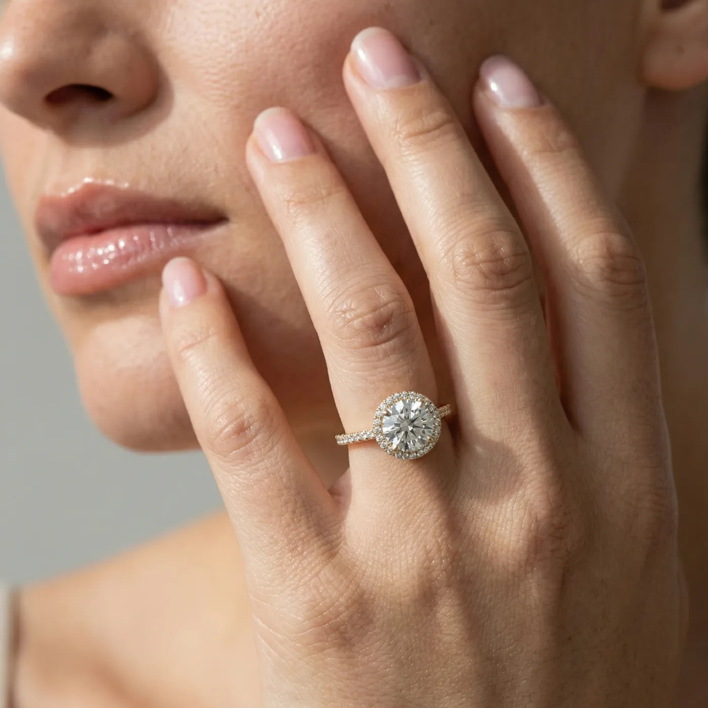 Rosettring i gult gull med 2,49 carat diamanter på modell i naturlig lys.
