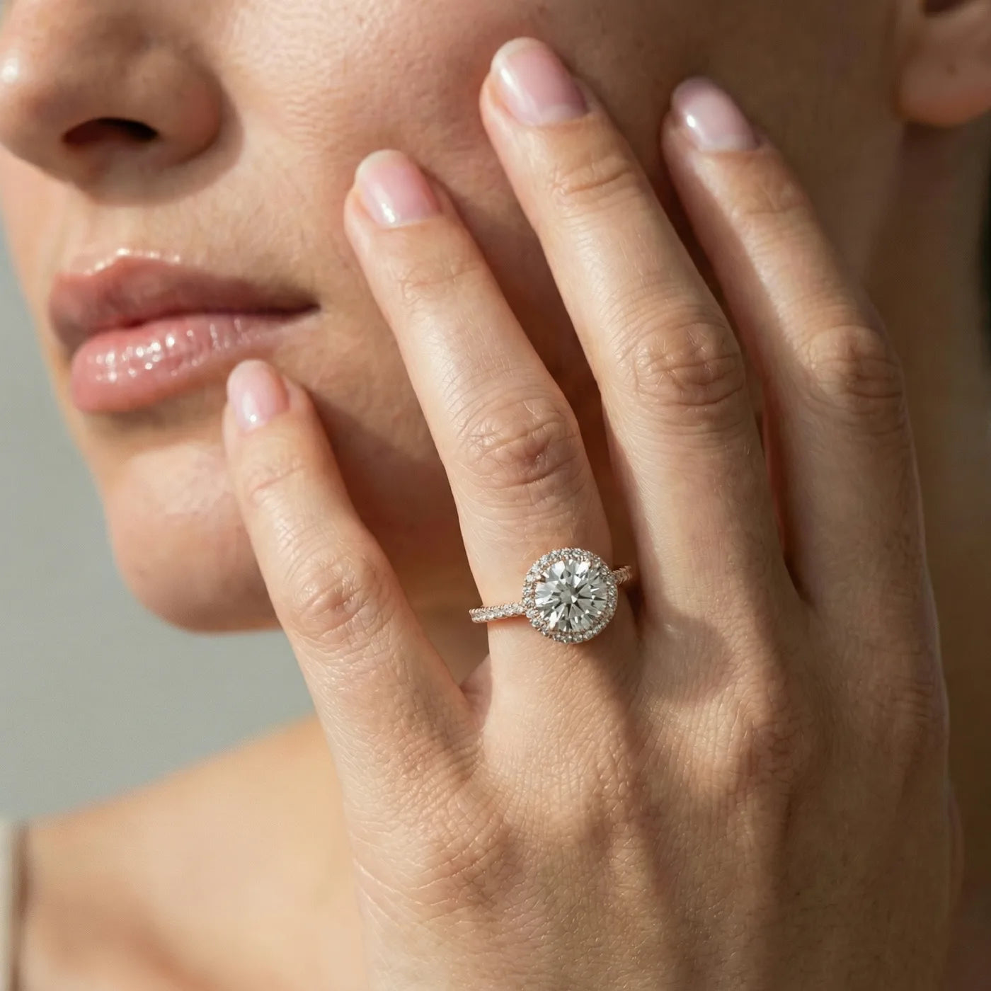 Rosettring i rosegull med 2,49 carat diamanter på modell i naturlig lys.