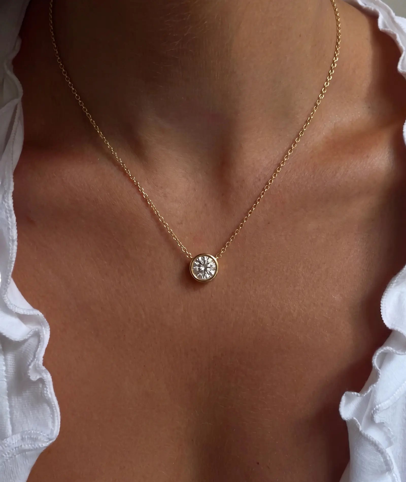 Rund diamanthalskjede i bezelinnfatning, 14K gult gull på modell