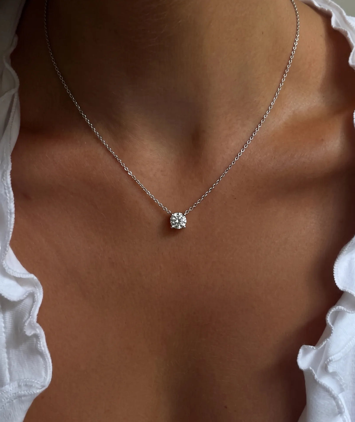 Rundt diamanthalskjede i kloinnfatning, 14K gult gull på modell.