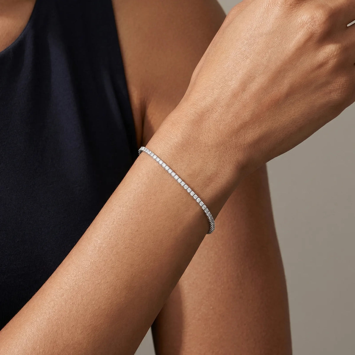 Tennisarmbånd i hvitt gull med 2 carat diamanter på armen il modell - up close.